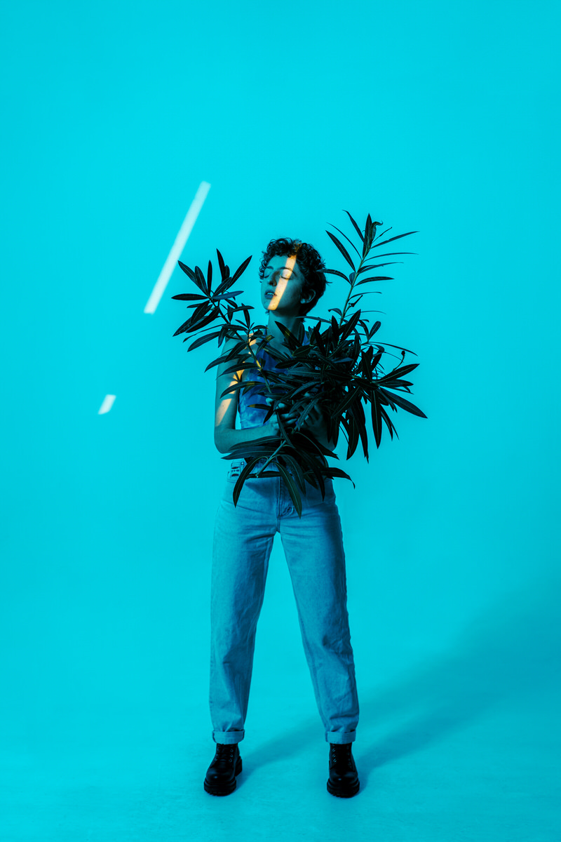 Androgynous model with bunch of leaves