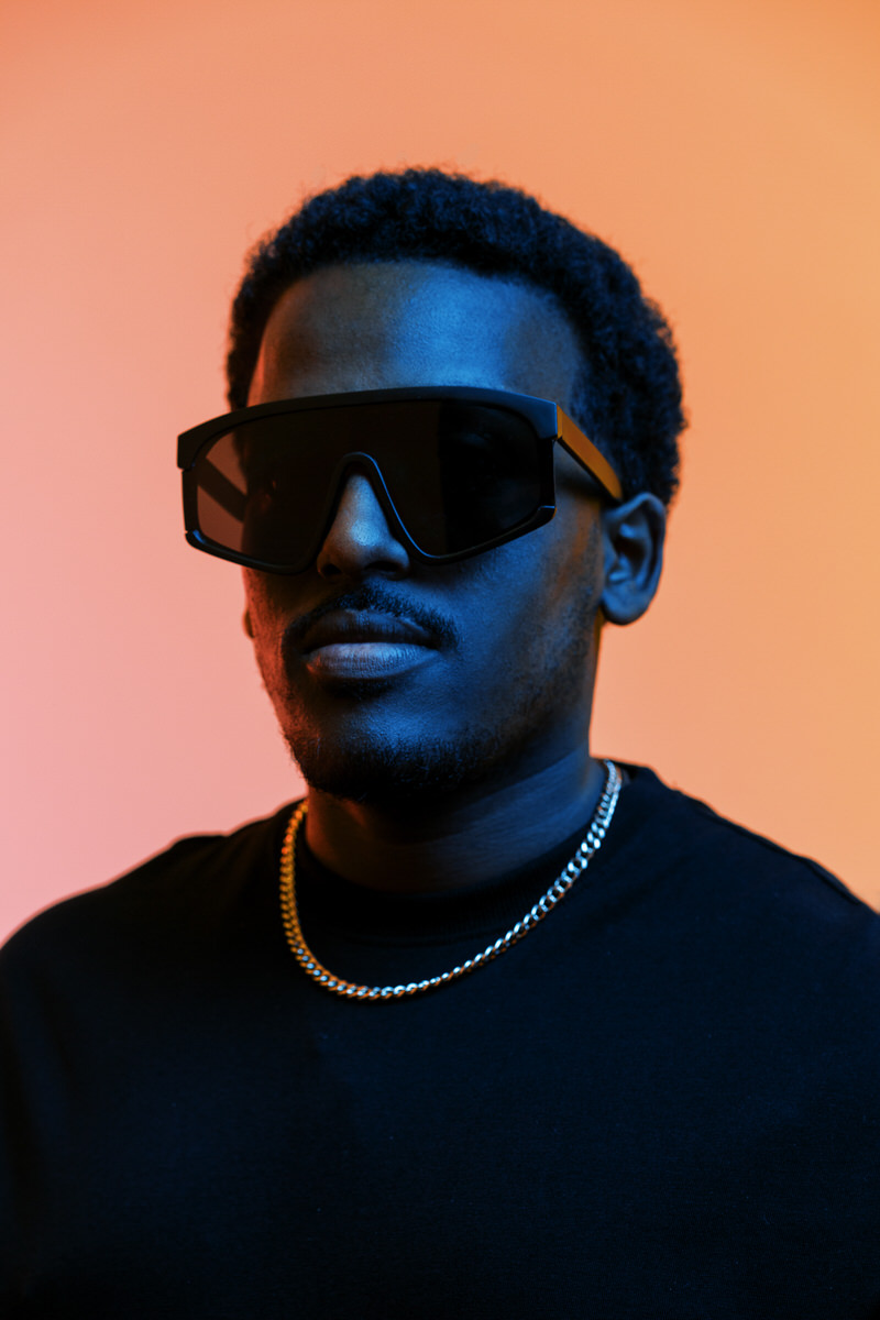 Stylish black man in sunglasses in studio