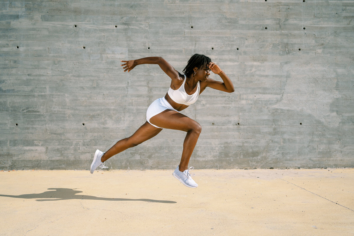 Energetic black sportswoman running in city