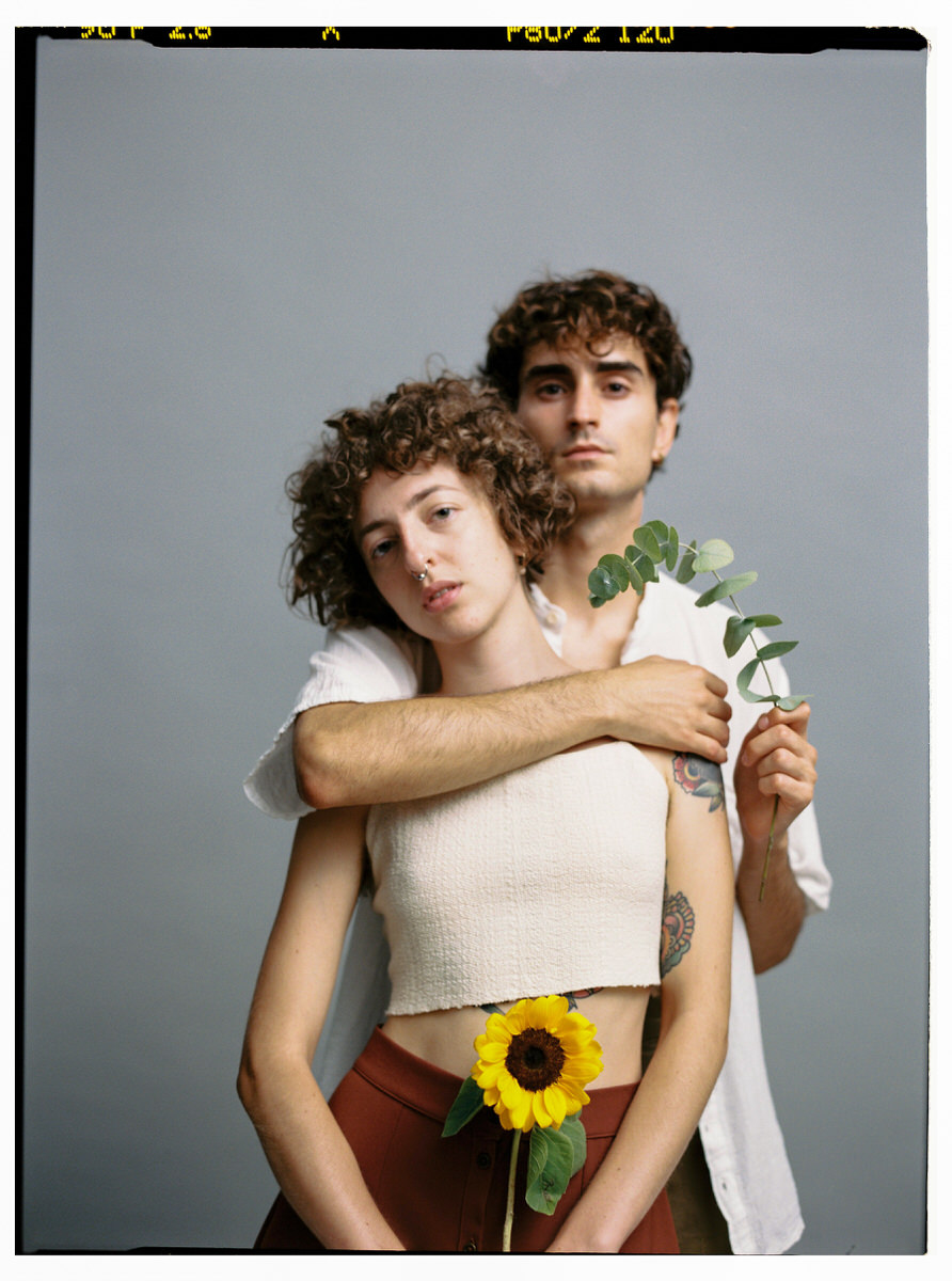 Tender couple with flower in studio